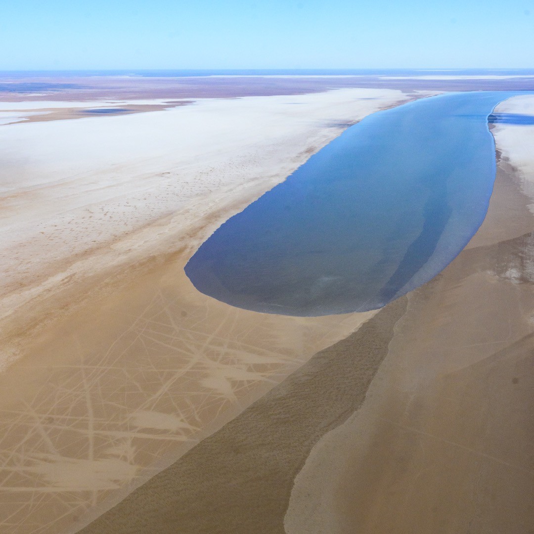 Image: The dark tongue of approaching water contrasts dramatically with the lake's sandy, salty surface. Source: Keiko Dalby (@keikointas on Instagram)